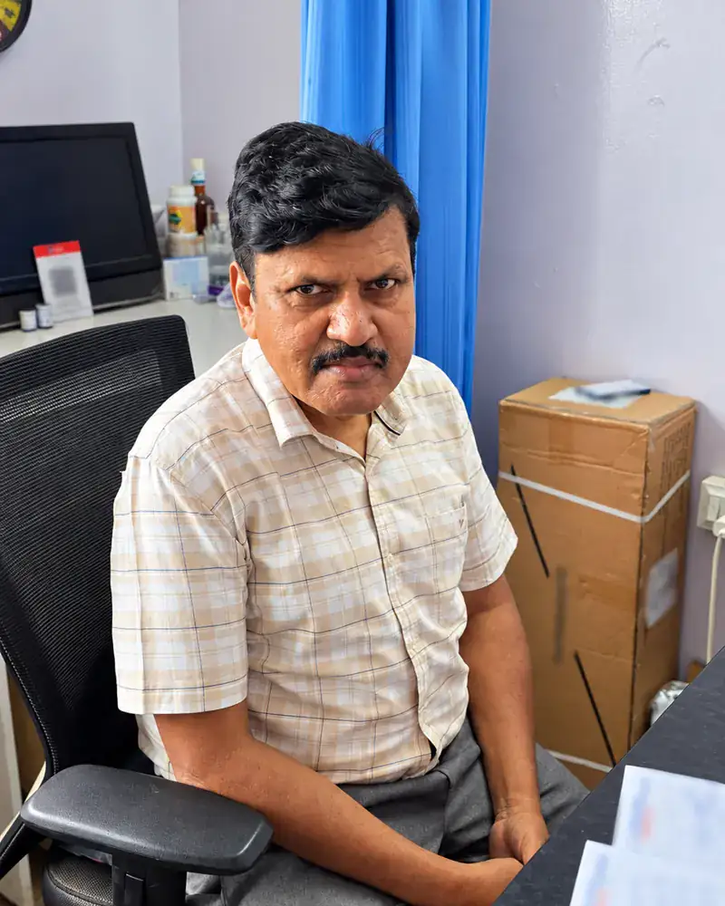Dr. Mailan K seated in the consultation room at Curewell Speciality Clinic